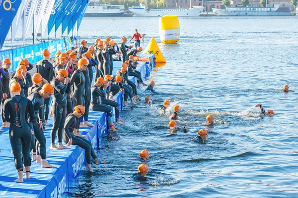 Woman triathletes in orange caps waiting for the start on the je — Stok fotoğraf