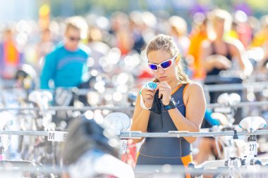 Female triathlete preparing and fixing with her goggles before t