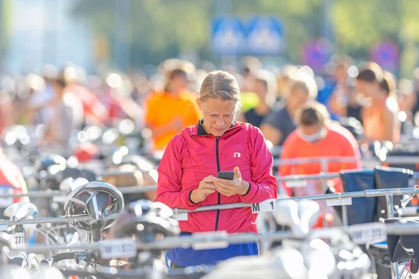 Triathletin checkt Smartphone vor der WM — Stockfoto