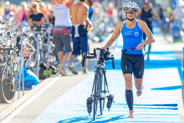 Female triathlete running with bike in the transition area the I — Zdjęcie stockowe