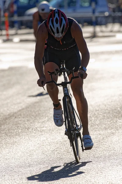 Male triathlete cycling just after the transition area the ITU W — Stock Photo, Image