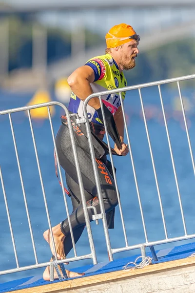 Triathlete with beard running up on a footboard after the swimmi — Stok fotoğraf