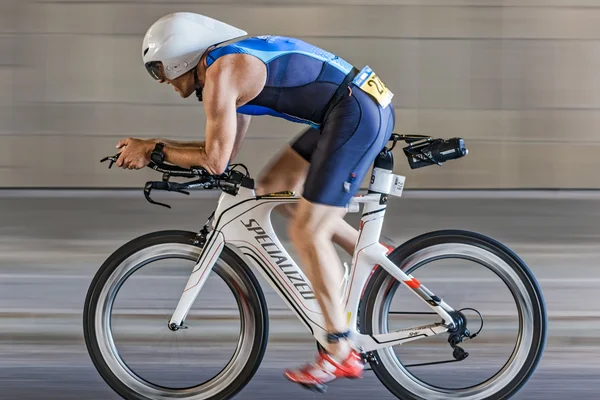 Male triathlete cycling into a tunnel with motion blur of the pa — Stok fotoğraf