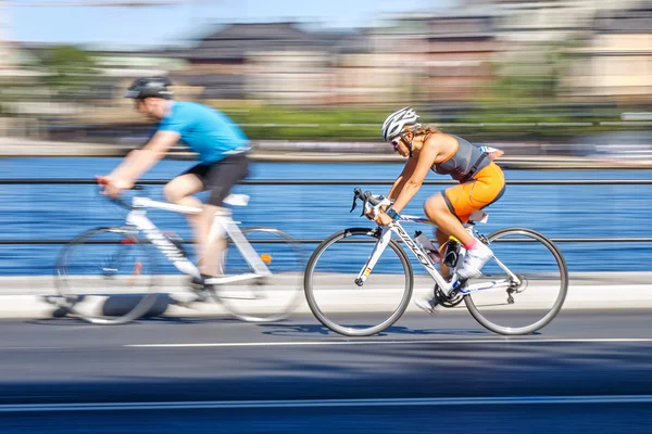 Feminino triatleta passando um piloto na parte de ciclismo com motio — Fotografia de Stock