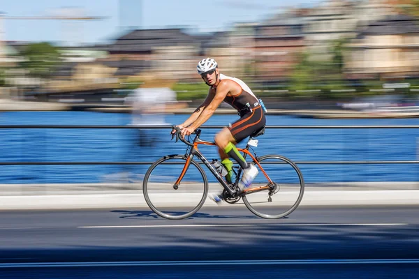 Ciclismo de triatleta con desenfoque de movimiento de la panorámica y mirando i —  Fotos de Stock