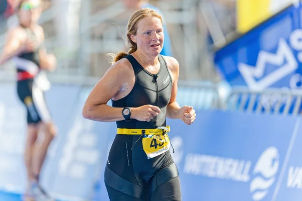 Female triathlete passing the finish line at the ITU World Triat — Stok fotoğraf