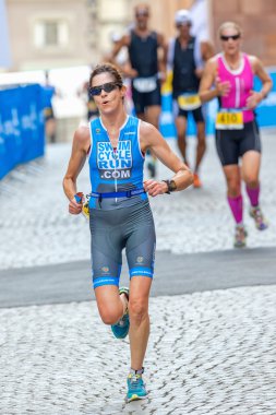 Woman triathlete running down the cobblestones in the old town a