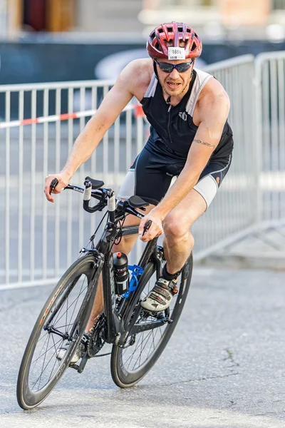 Male triathlete leaning on a bike in a curve at the old town in — 스톡 사진