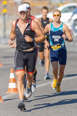 Group of triathletes running on the asphalt road at ITU World Tr