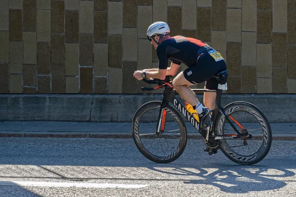 Ciclismo de triatleta con una bicicleta rápida a la luz del sol parcial en el — Foto de Stock