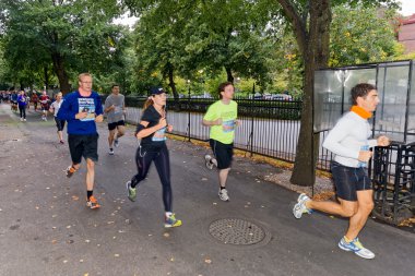 Group of runners outside of the Stockholm Olympic Stadium in mot