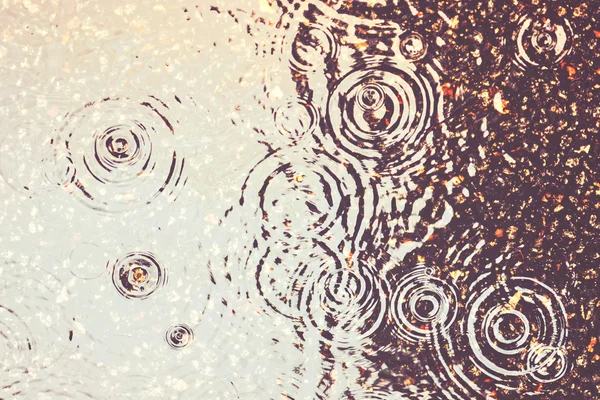 Rain on asphalt or tarmac road creating ripples filtered — Stock Photo, Image