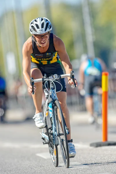 Fast female triathlete leaning in a curve on the bike at the ITU — Stok fotoğraf