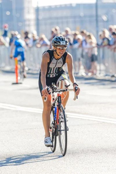 Female triathlete on the bike in bright light at the ITU World T — Stock fotografie