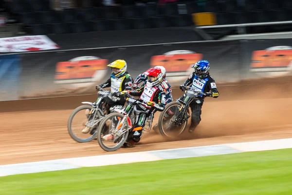 Action image of a group of speedway racers going into a curve at — стокове фото