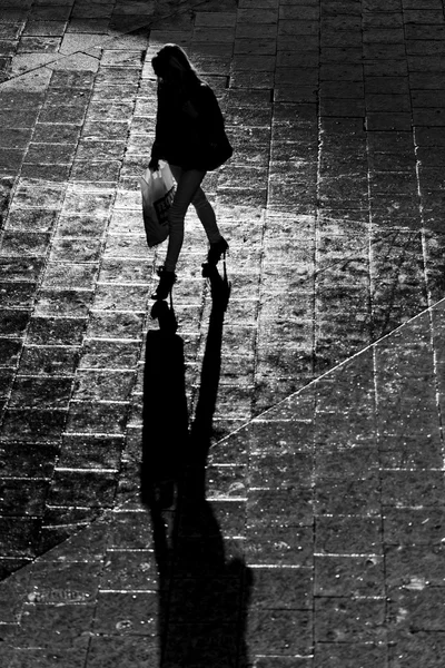 Силуэт женщины-покупателя с длинными черными тенями — стоковое фото
