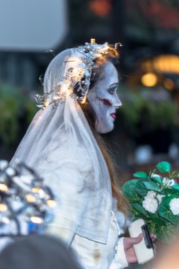 Sideview of a woman in a bride costume at Halloween parade Shock
