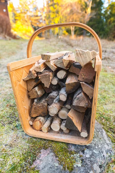 Firewood basket outside on frosty grass during winter. — Stock Photo, Image