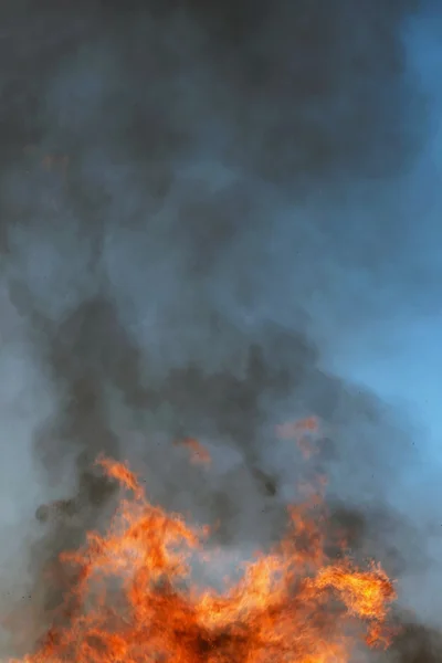 Mohutný plamen proti modré obloze — Stock fotografie