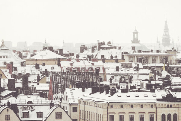 STOCKHOLM, SWEDEN - JAN 8, 2016: Snowy rooftops at Stockholm Old Town. Filters applied