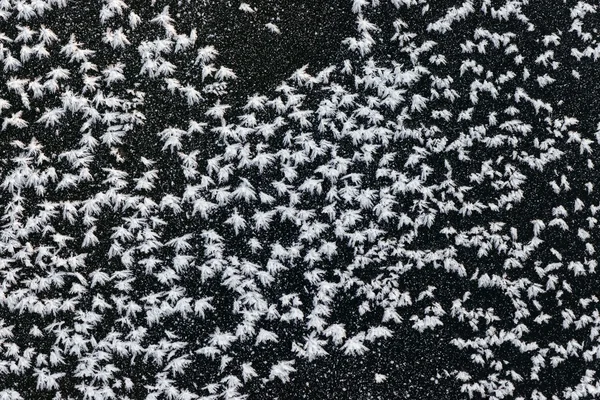 White frost formations on black ice