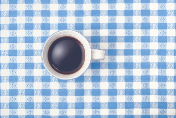 Vista superior da caneca de café preto na toalha de mesa verificada — Fotografia de Stock