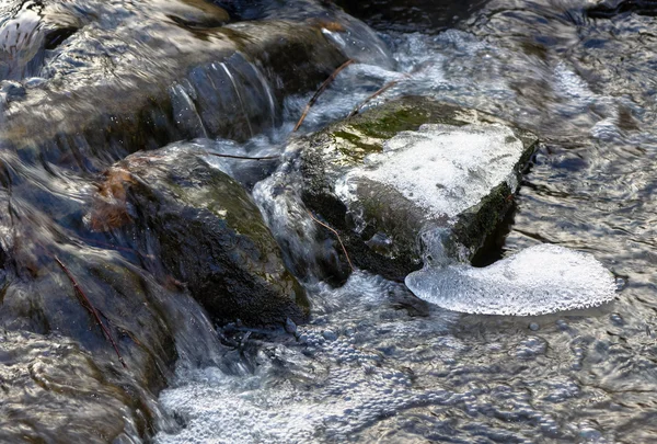 春先に残っていくつかの氷の中に水の流れ — ストック写真