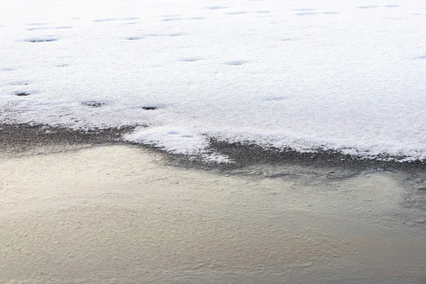 Isig sjö med ett snötäcke som börjar en bit från stranden — Stockfoto