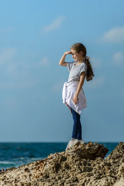 年轻美丽的女孩过大海的岩石 — 图库照片