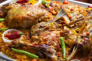 Büyük bir tabak geleneksel Orta Doğu Mandi pilavı. Üstünde yavaş kavrulmuş kuzu eti ve kırmızı biber var.