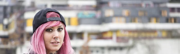 Woman with piercings and pink hair at housing estate — Stock Photo, Image