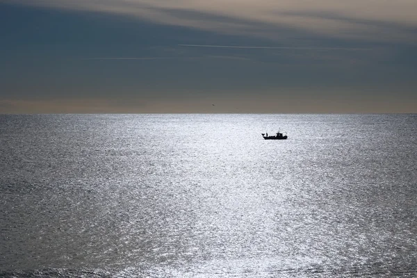 Fisherman boat backlit as silhouette — Stock Photo, Image