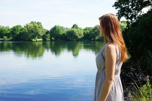 Young woman looking at idyllic lake — Stock Photo, Image