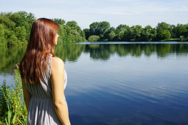 Young woman overlooking idyllic lake — Stock Photo, Image