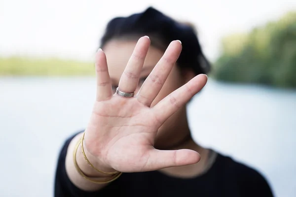 Frau versteckt Gesicht hinter Hand — Stockfoto