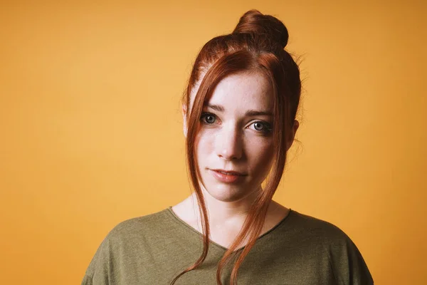 Coole junge Frau mit rotem Haar, unordentlicher Dutt-Frisur und lockeren Strähnen — Stockfoto