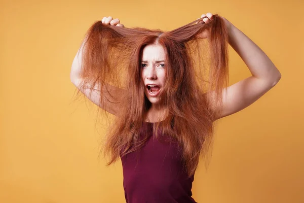 Frustrado jovem mulher puxando e rasgando seu cabelo — Fotografia de Stock