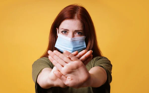 Social distansering - ung kvinna bär medicinsk ansiktsmask gör stop hand gest — Stockfoto
