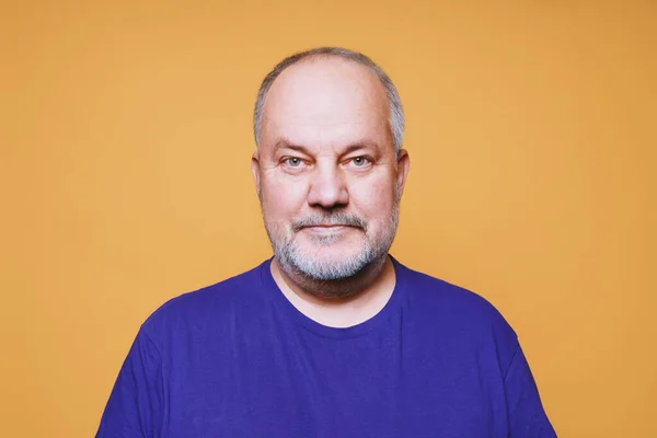 Senior Mann mit grauen weißen Haaren und Bart vor orangefarbenem Studiohintergrund — Stockfoto