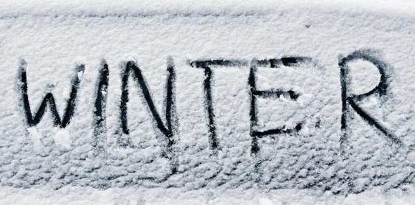 Invierno escrito en nieve en la ventana del coche — Foto de Stock