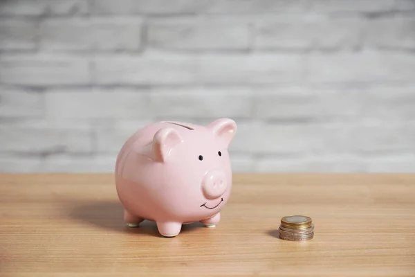 Sparschwein mit Stapel Euromünzen auf dem Tisch — Stockfoto