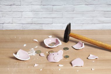 broken Piggy bank smashed into pieces with hammer and small change clipart