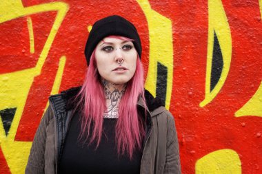 young woman e-girl style in front of graffiti wall