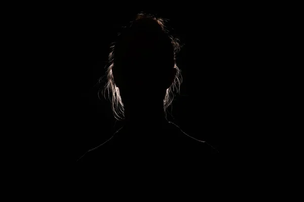 Silueta de retrato retroiluminada de mujer irreconocible escondiendo cara e identy en la sombra oscura — Foto de Stock