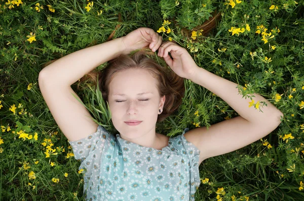 Young woman sleeping in a flower meadow — Stock Photo, Image