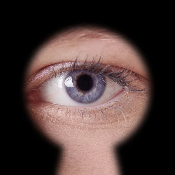 Eye looking through keyhole — Stock Photo, Image