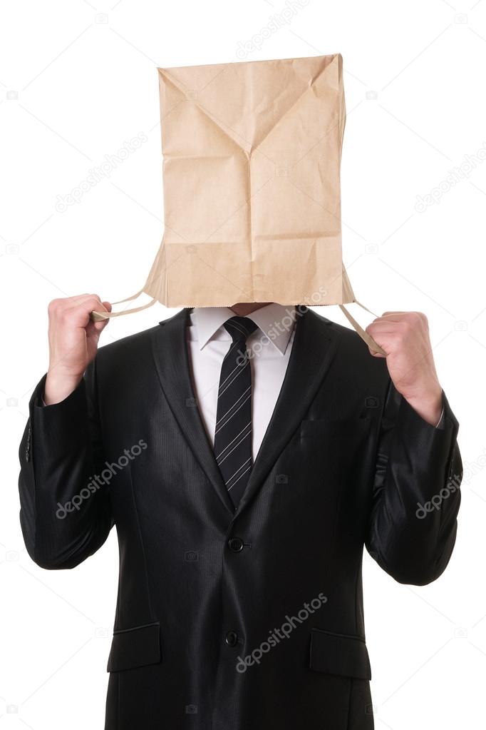 businessman pulling paper bag over his head