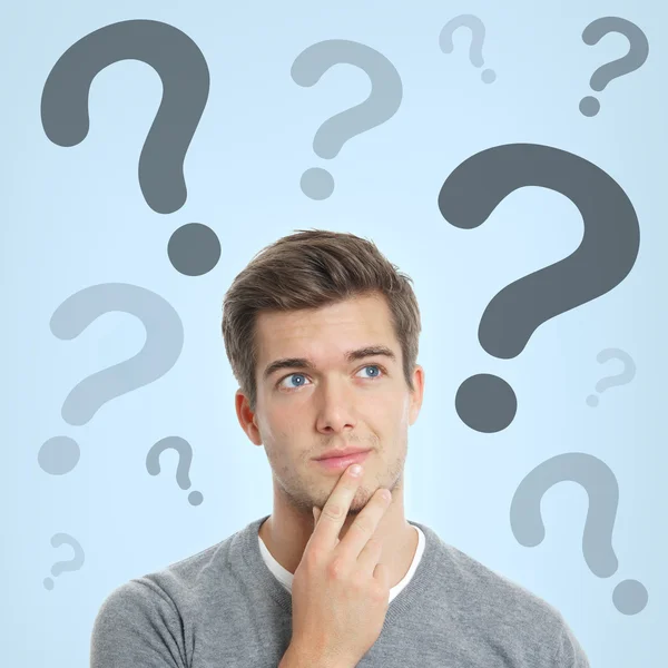 Young man with question marks — Stock Photo, Image