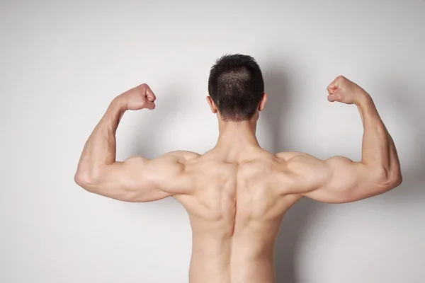 man flexing biceps and back muscles