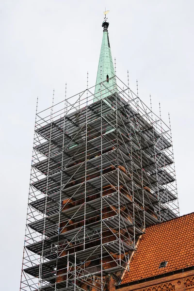 Kyrkan står hög med byggnadsställningar — Stockfoto